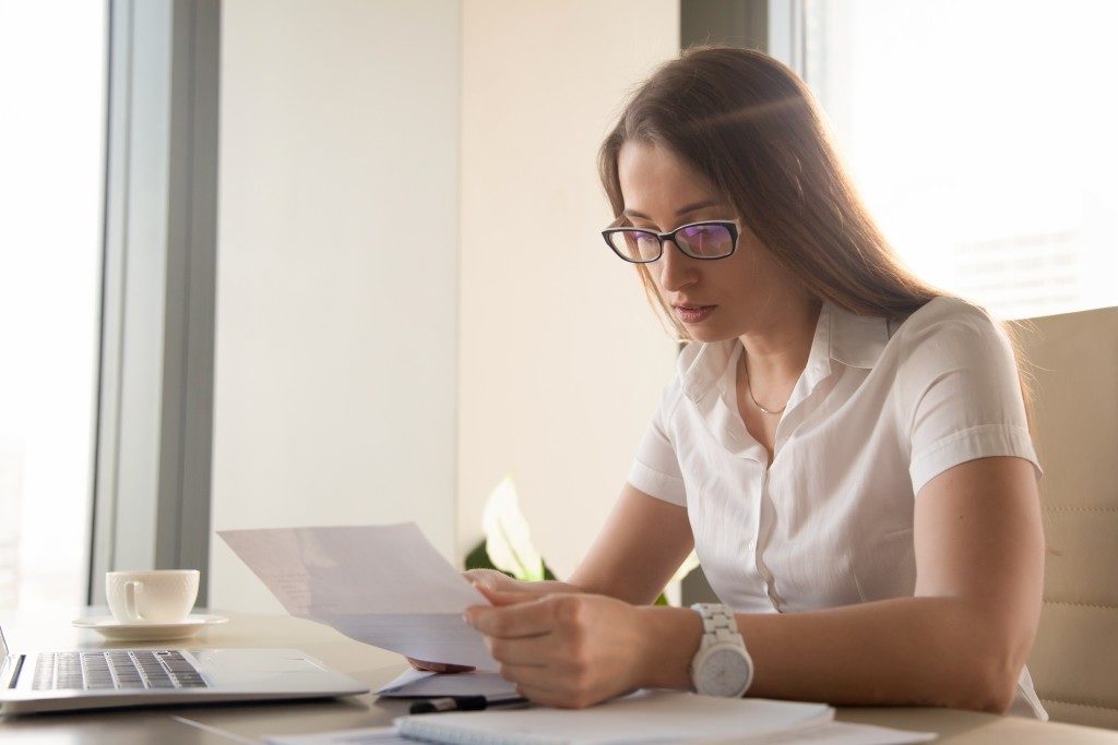 woman in glasses looking at her bill