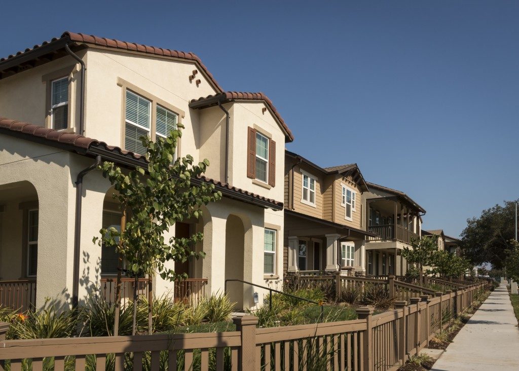 ow of new homes with fenced yards along a sidewalk