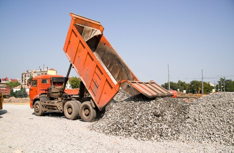 orange truck pouring over gravel