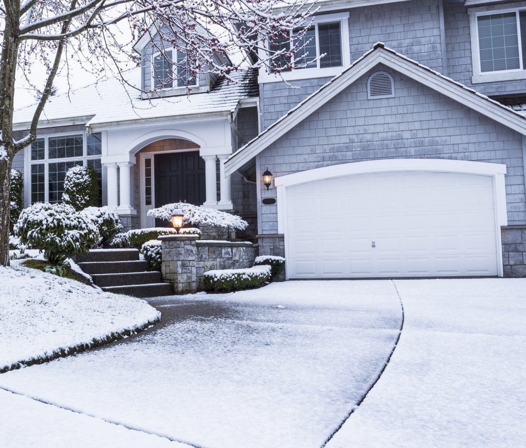 suburban home with snow on drive way