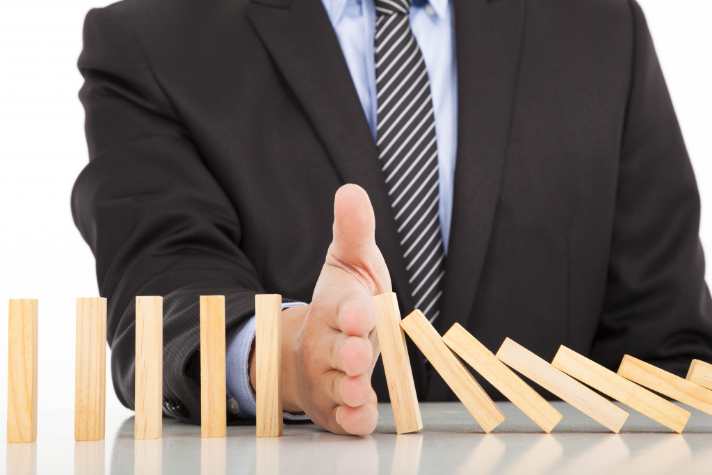 businessman preventing downfall concept