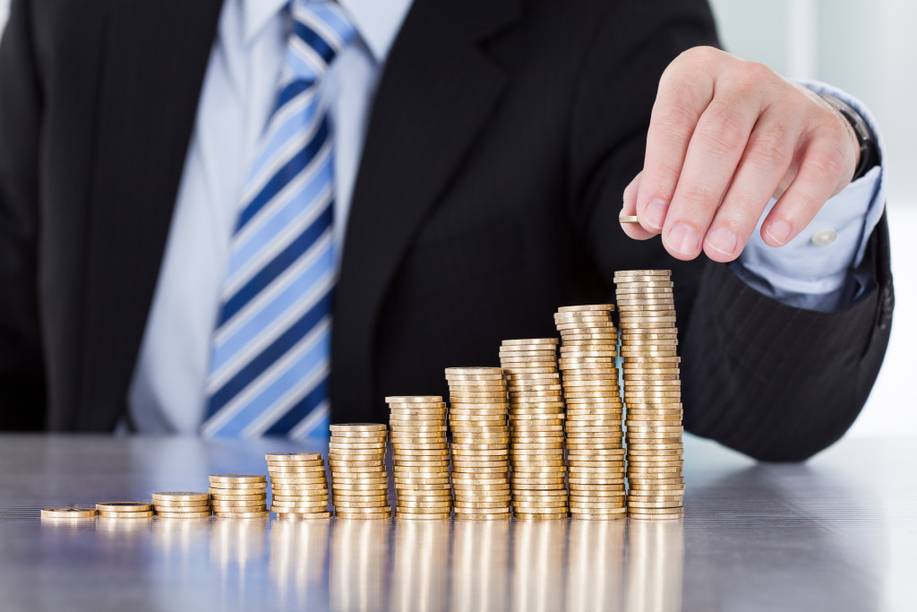 businessman stacking up coins to show investment and growth