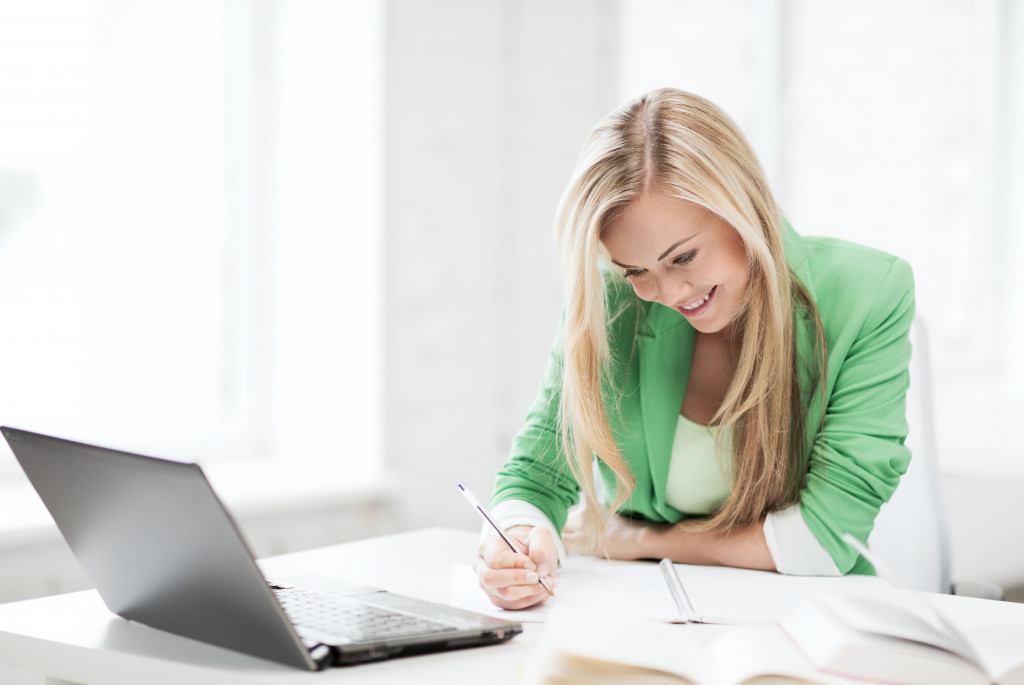 a female real estate agent working on laptop and notebooks