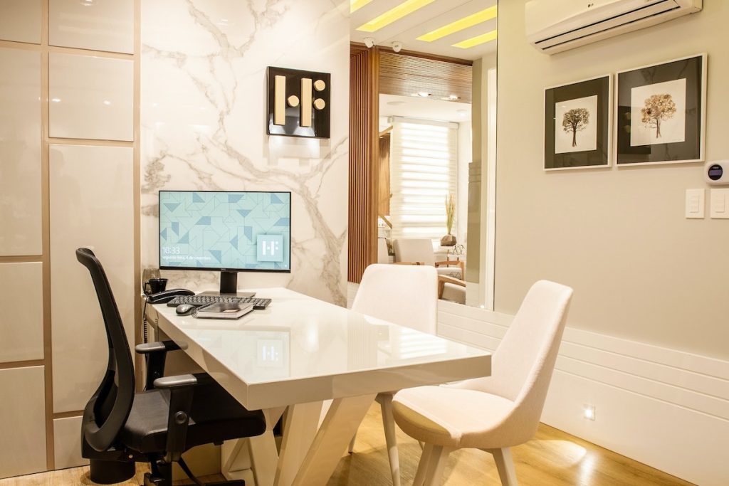 Turned-on Black Flat Screen Monitor on White Wooden Table and Chairs