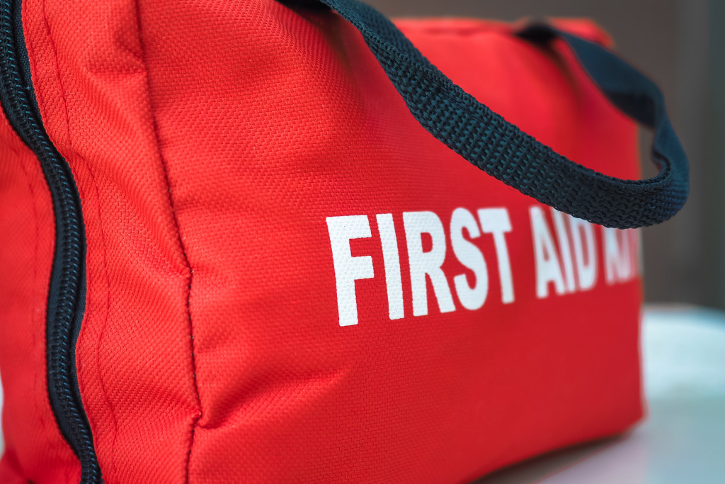 A red bag labeled First Aid Kit