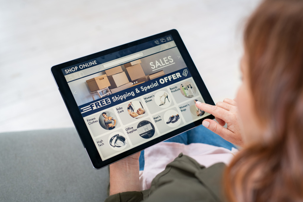 Woman checking the products on an e-commerce site using a tablet.