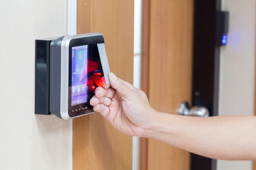 person tapping access control ID to a door lock